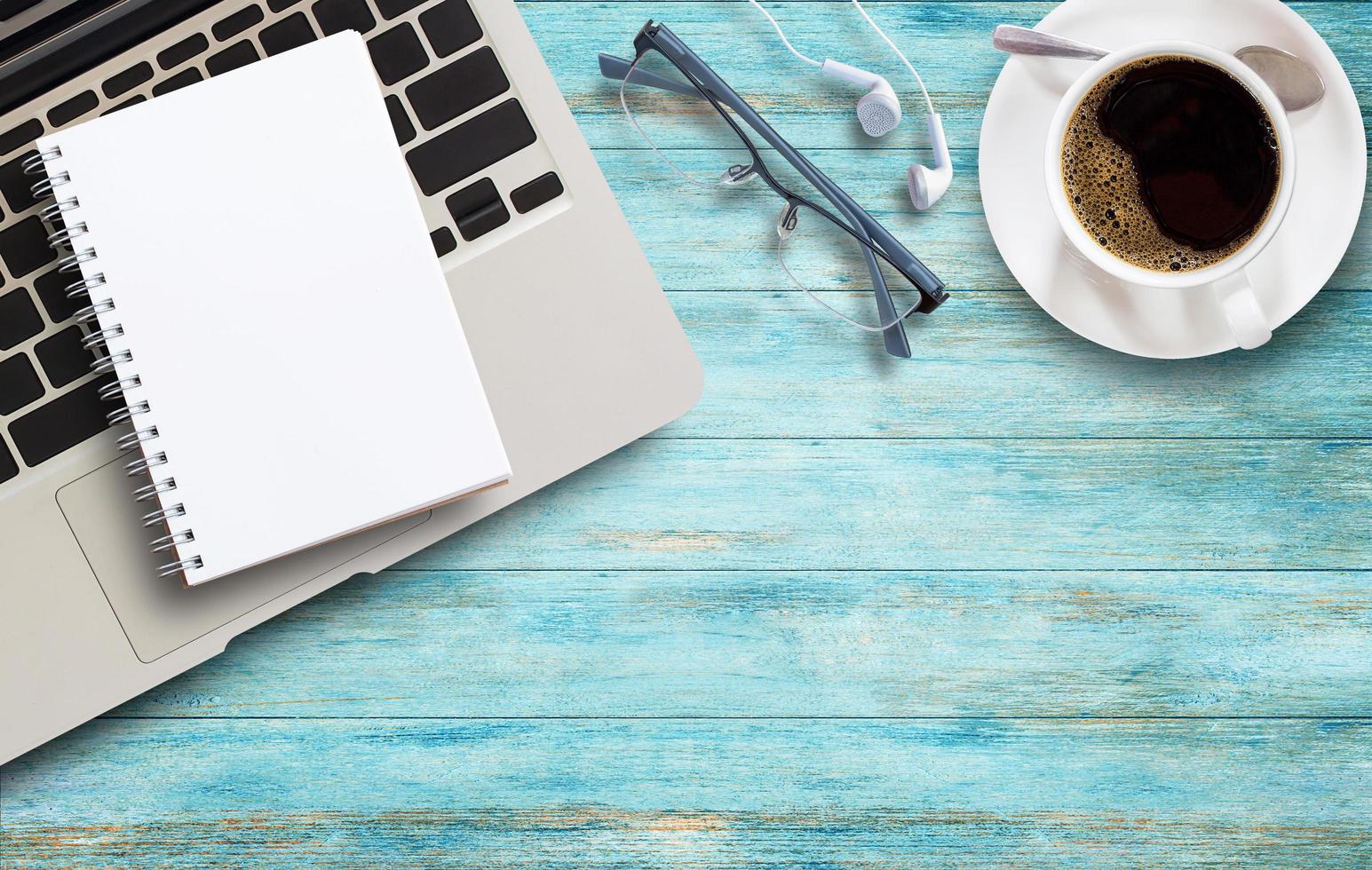 scrivania da ufficio con laptop, caffè e bicchieri su legno foto