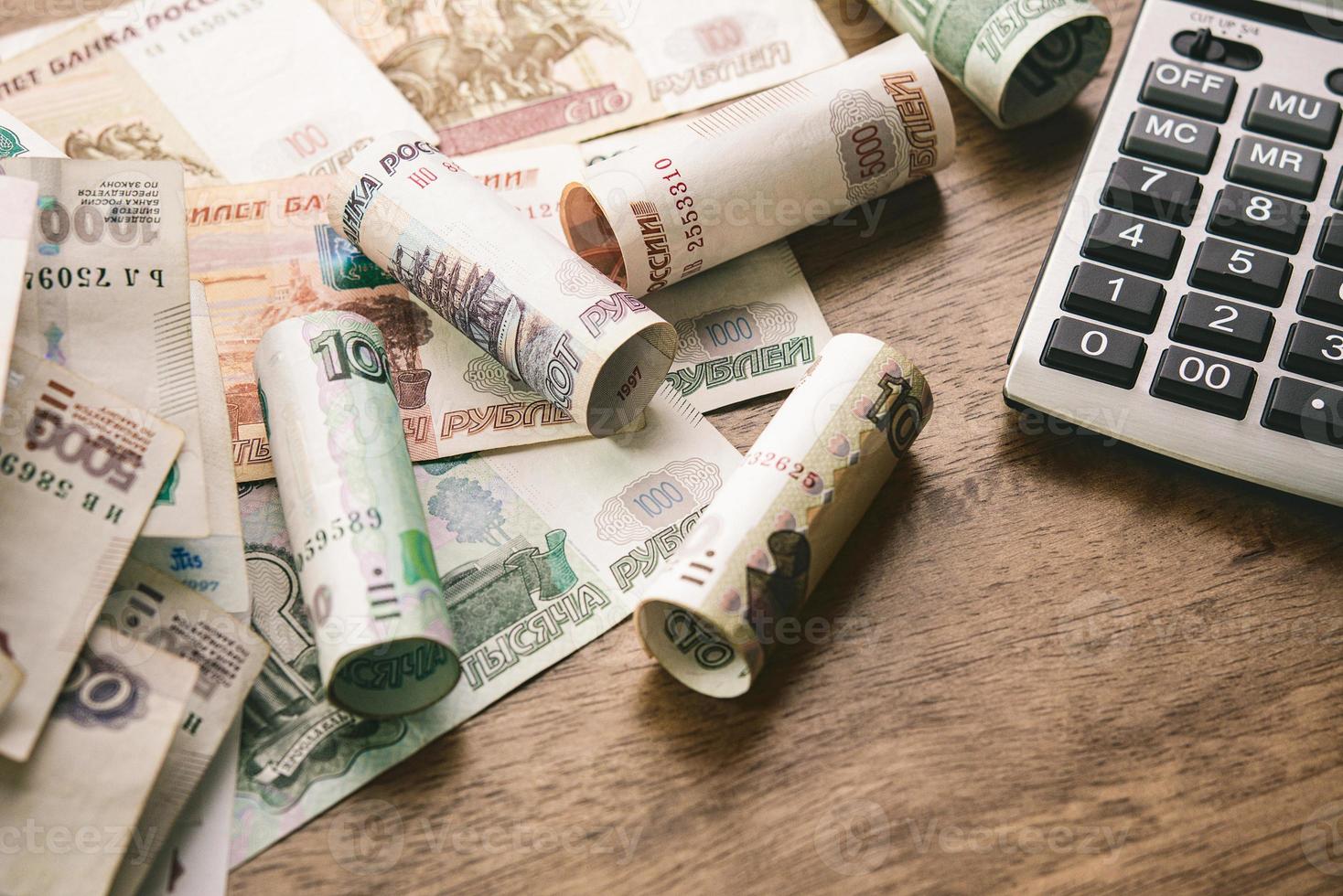 soldi del rublo russo con la calcolatrice sul fondo della tavola di legno per i concetti finanziari e di investimento foto