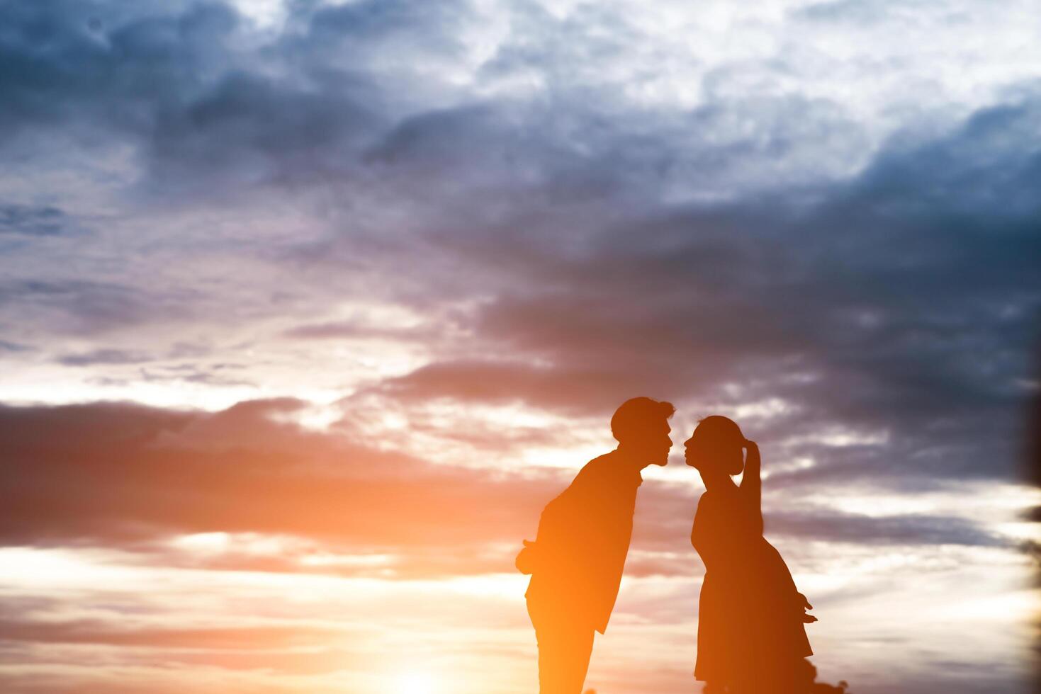 silhouette di coppia dolce baciare su sfondo tramonto. foto