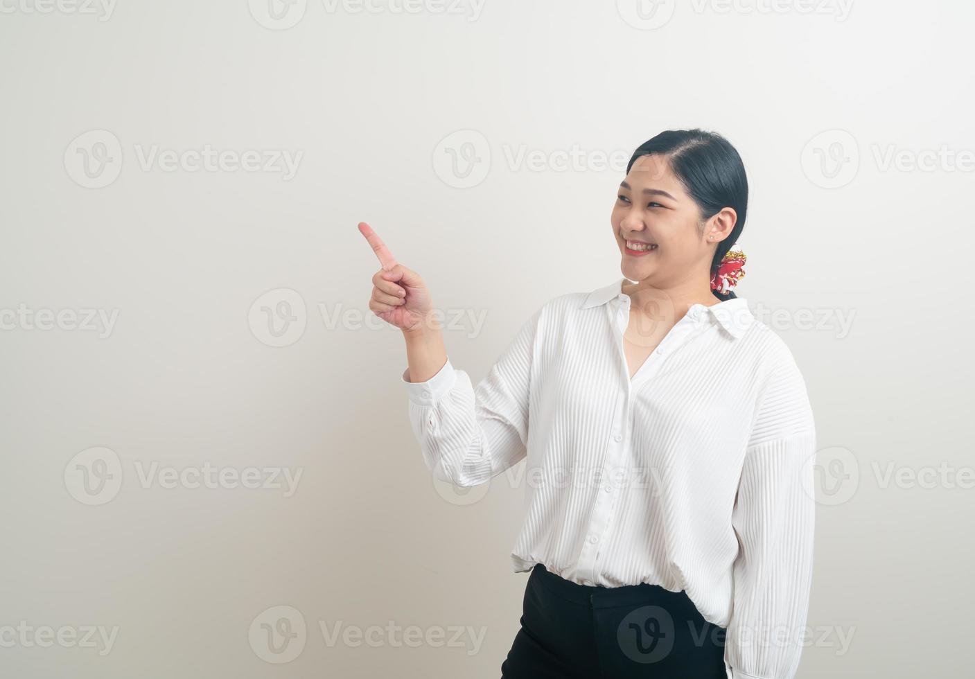 donna asiatica con la mano che punta su sfondo bianco foto