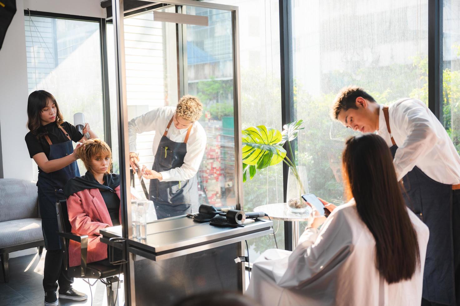 parrucchiere e bella donna del cliente che fanno il trattamento della cura dei capelli nel salone di stile di moda foto