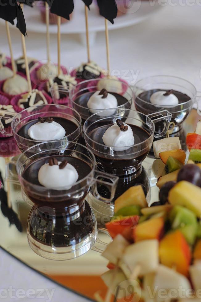 primo piano del vassoio con molte deliziose torte di pasticceria tortine e amaretti di fila. dolci freschi, multicolori, colorati, verdi, gialli, bianchi e rosa ai frutti di bosco, splendidamente decorati foto