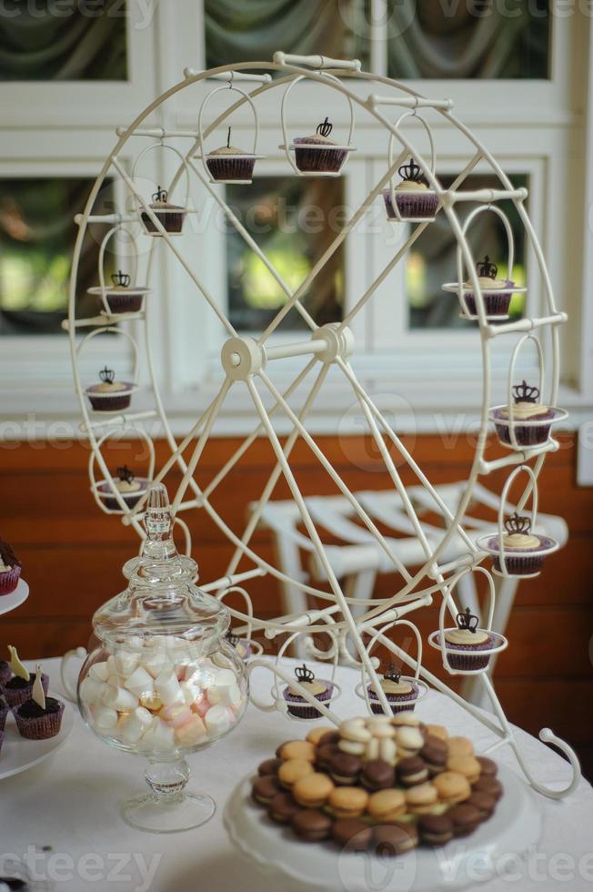 primo piano del vassoio con molte deliziose torte di pasticceria tortine e amaretti di fila. dolci freschi, multicolori, colorati, verdi, gialli, bianchi e rosa ai frutti di bosco, splendidamente decorati foto