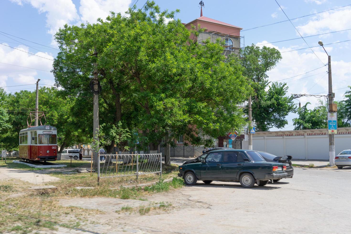 evpatoria, Crimea - 24 maggio 2018- monumento al primo tram sullo sfondo del paesaggio cittadino foto