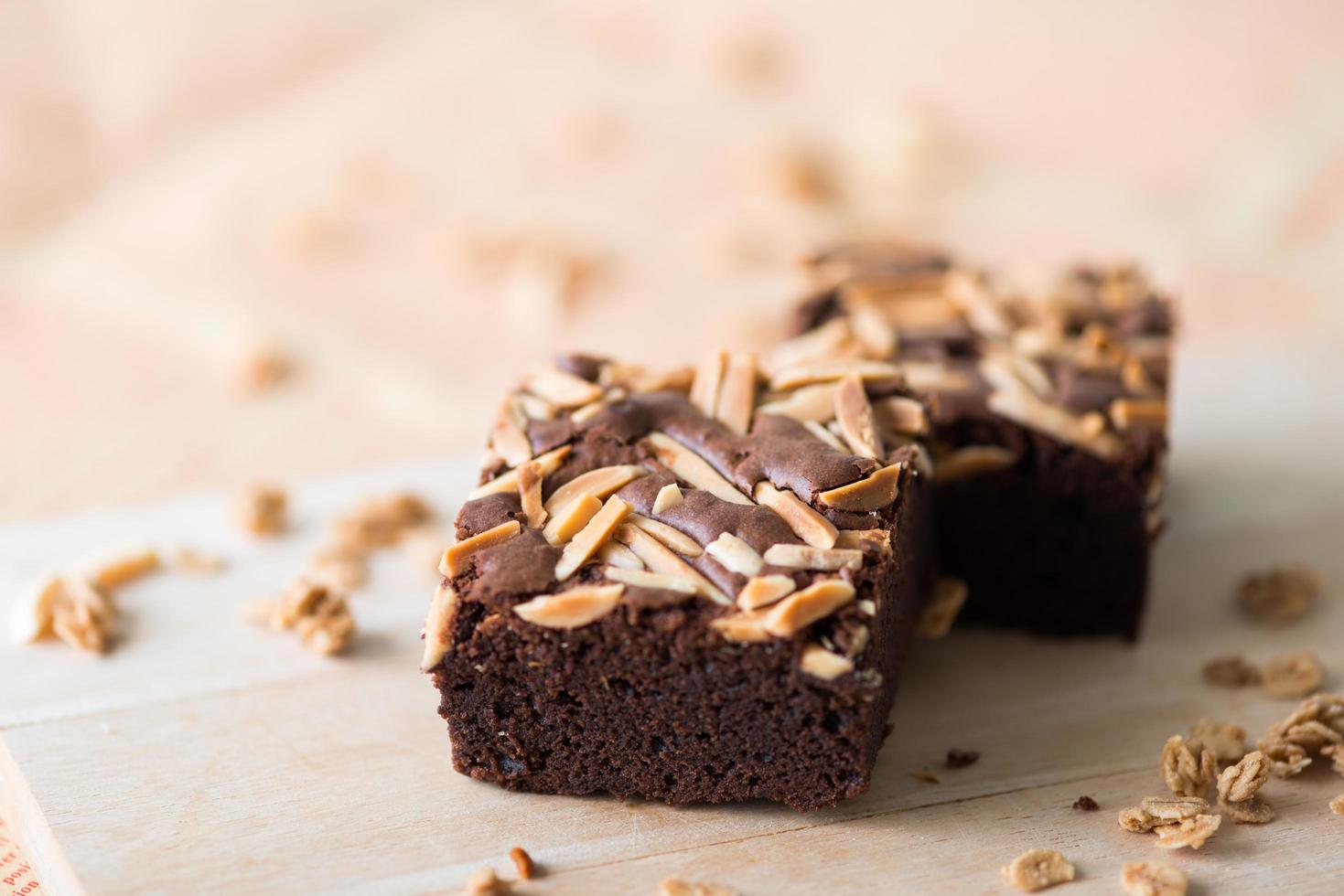 primo piano dolce brownie al cioccolato con guarnizione di mandorle, fuoco selettivo foto