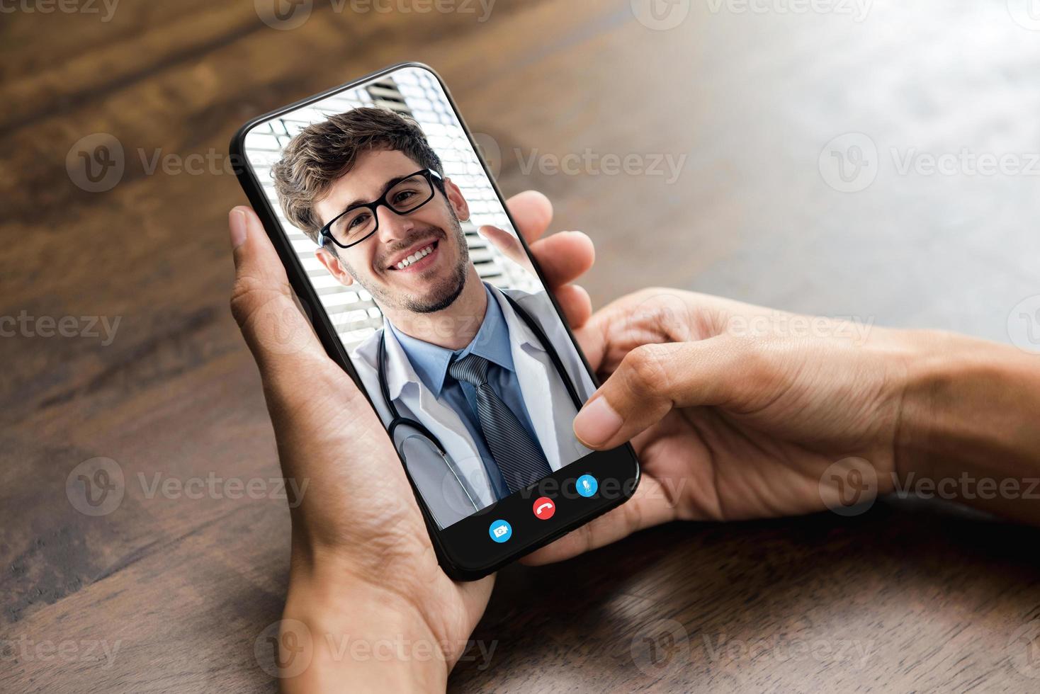 paziente che effettua una videochiamata con il medico online tramite smartphone, servizio di consulenza medica a domicilio e concetti di telemedicina foto