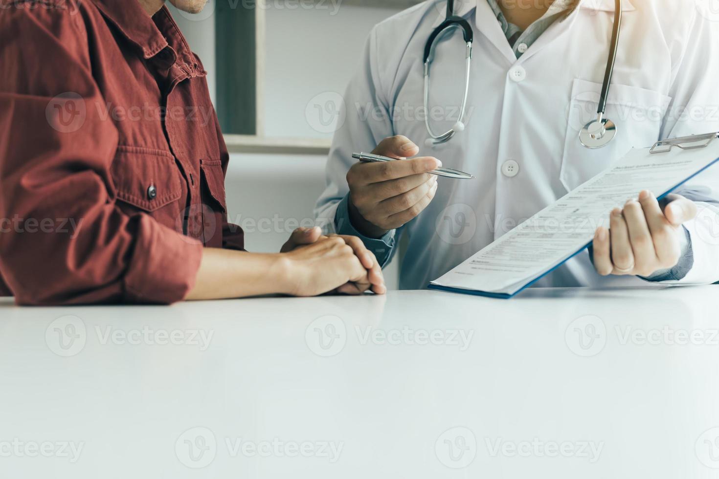mano del medico che tiene la penna e parla con il paziente di farmaci e cure. foto