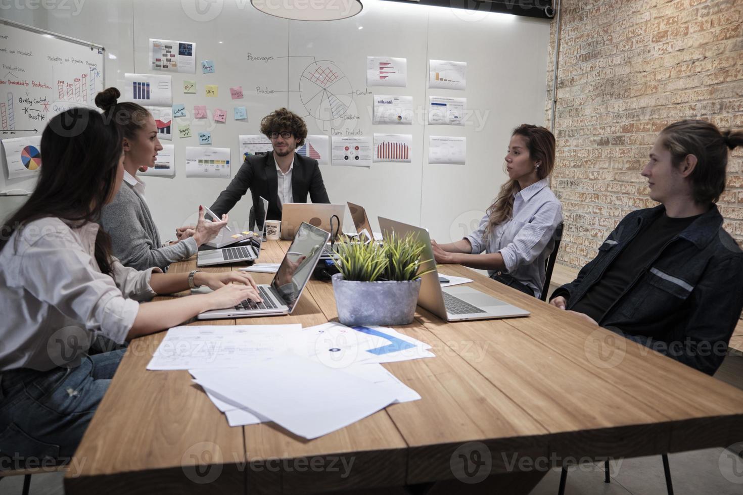 incontro di un team di professionisti, colleghi multirazziali e colleghi di lavoro e presentazione nella sala conferenze dell'ufficio commerciale con un manager maschio caucasico, discutendo di finanza e marketing. foto