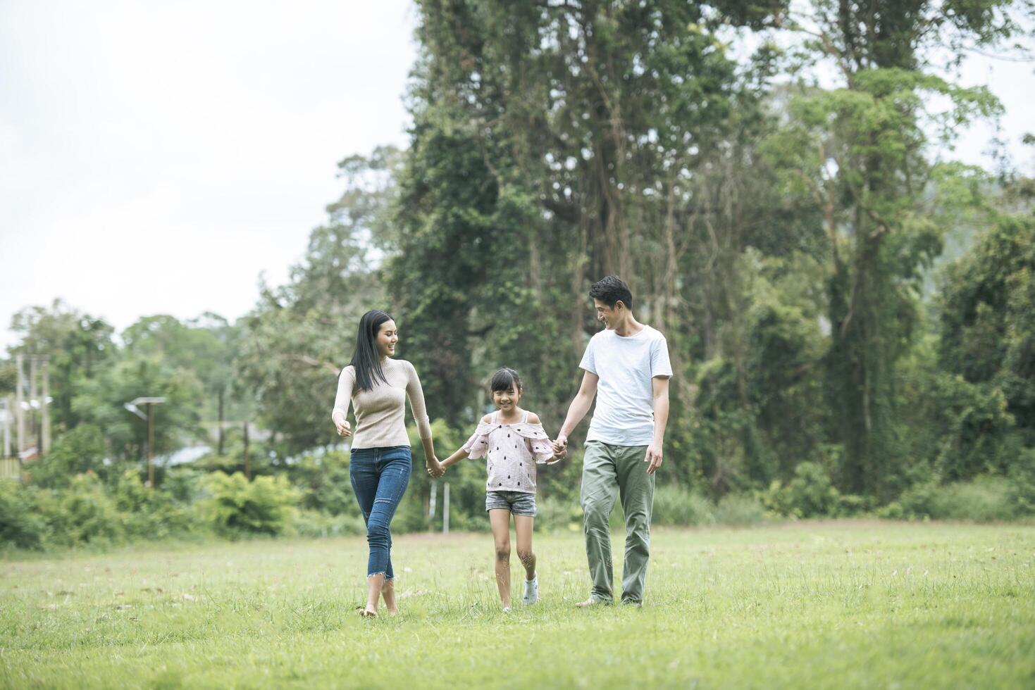 genitori felici e la loro figlia che camminano nel parco, concetto di famiglia felice. foto