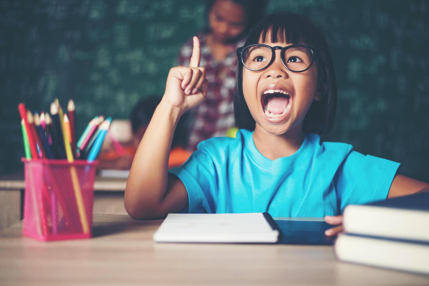 bambina premurosa con libro vicino a un consiglio scolastico foto