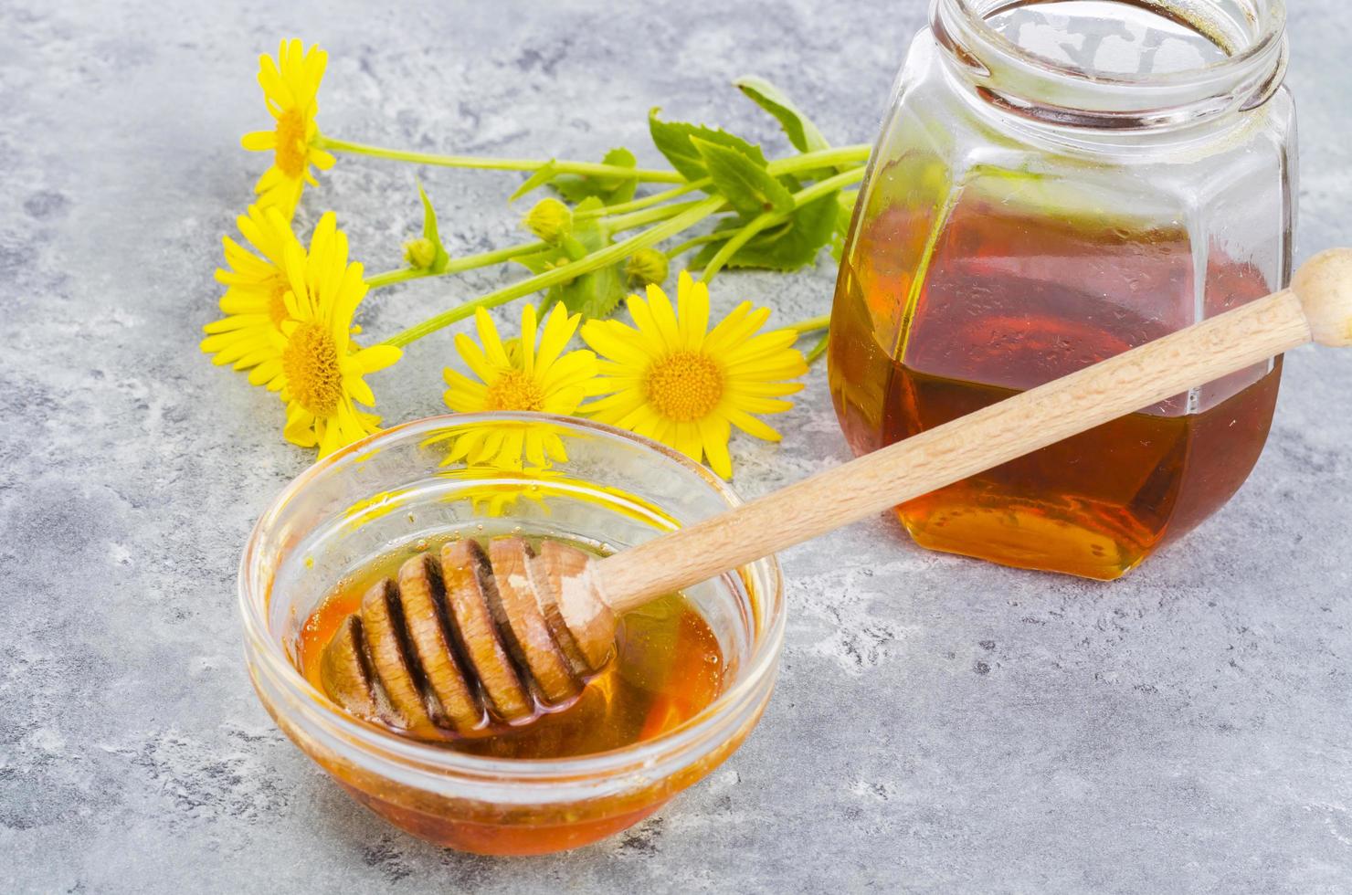 miele di fiori aromatici, fiori di campo su sfondo grigio. foto