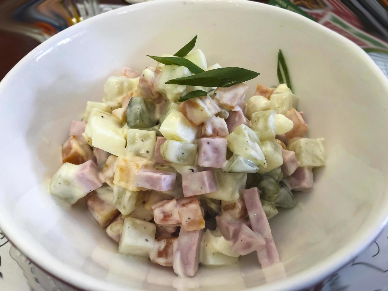 deliziosa insalata di olivier con verdure, salsiccia. foto