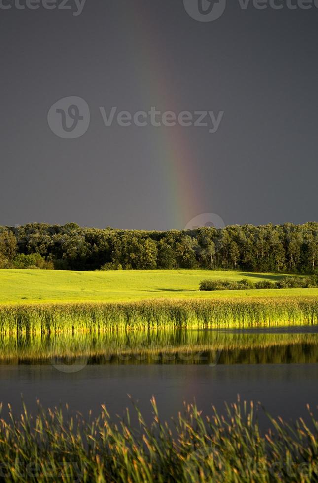 nuvole temporalesche prateria cielo arcobaleno foto