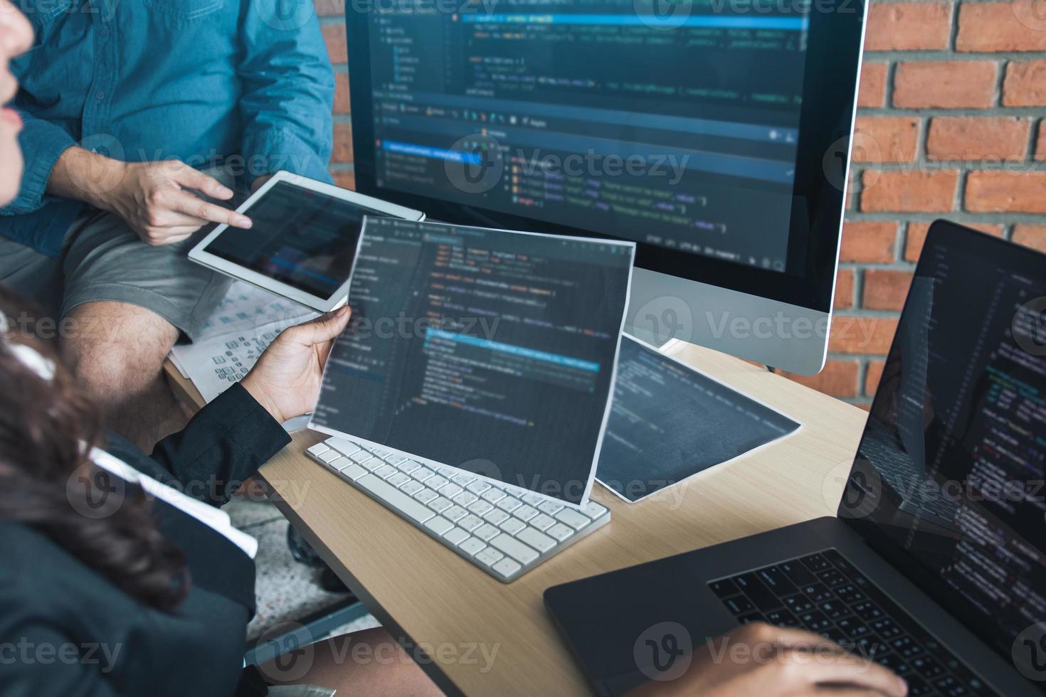 due sviluppatori di software stanno analizzando insieme il codice scritto nel programma sul computer. foto