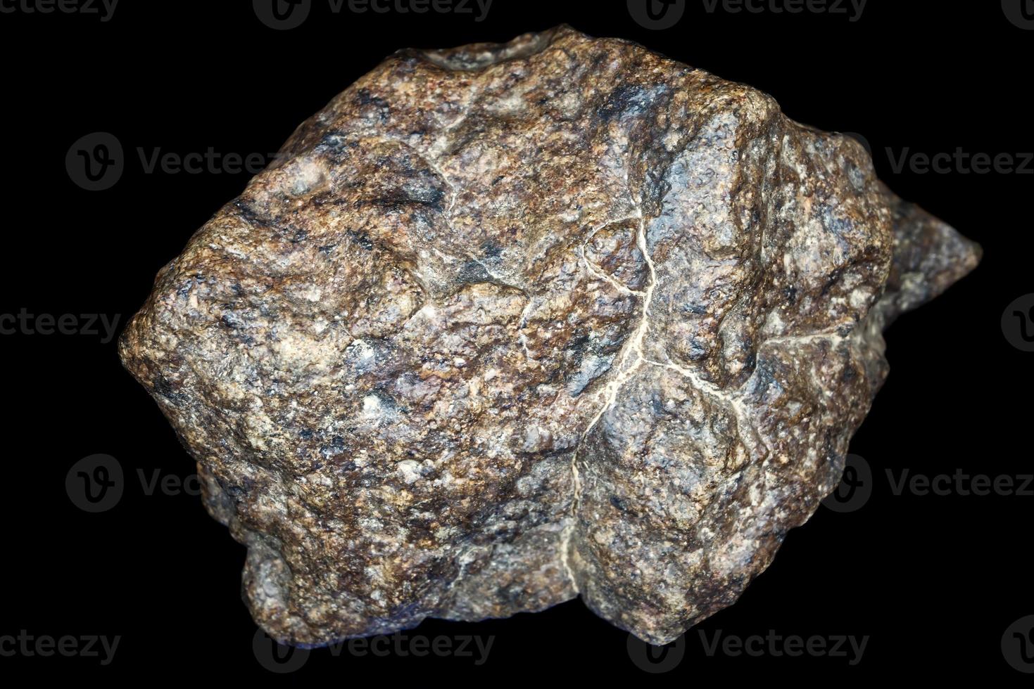 pietra di meteorite condrite isolata su sfondo nero. pezzo di roccia formatosi durante la creazione del sistema solare. foto