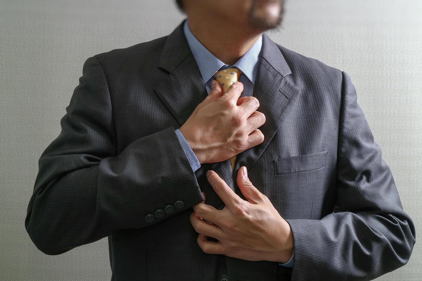 uomo d'affari che regola cravatta, vista frontale, senza testa. concetto di lavorare in un ufficio. foto