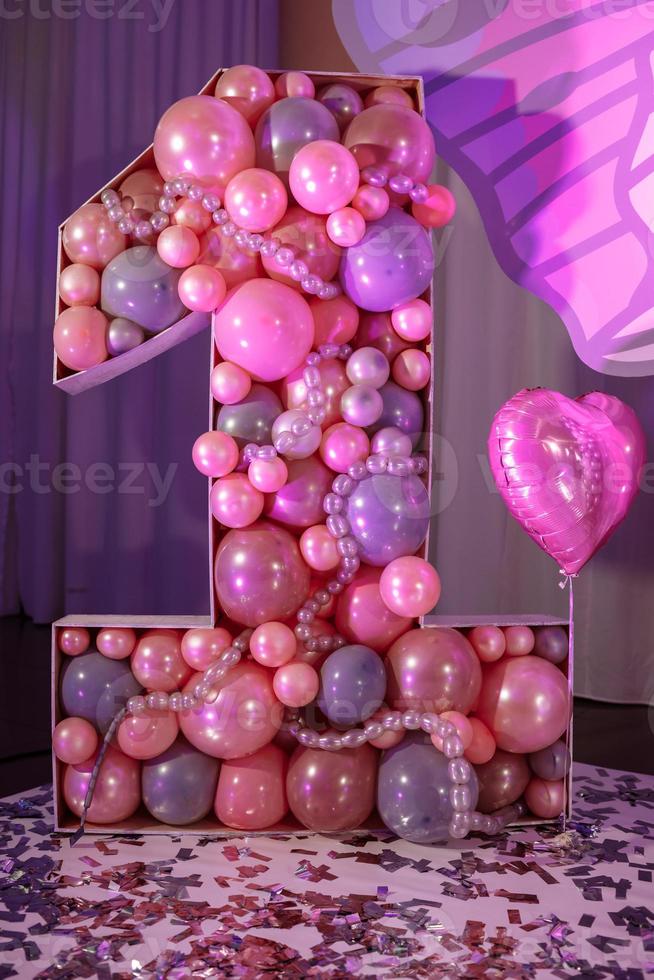 grande numero uno dei palloncini di colore rosa per il compleanno dei bambini. un interno chiaro, rosa e viola decorato per il primo compleanno della ragazza. festa di compleanno. foto