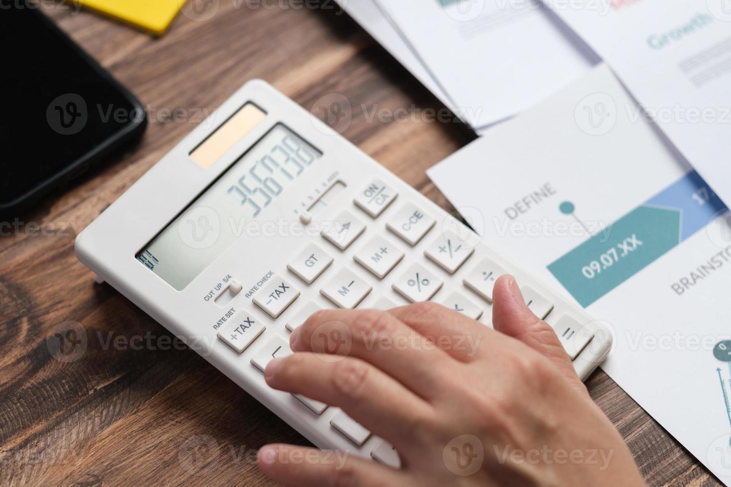 mano ravvicinata usando il calcolatore calcolare le tasse e il budget del progetto a casa foto