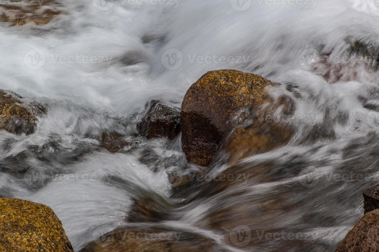 flusso di un fiume di montagna con pietre arrotondate foto