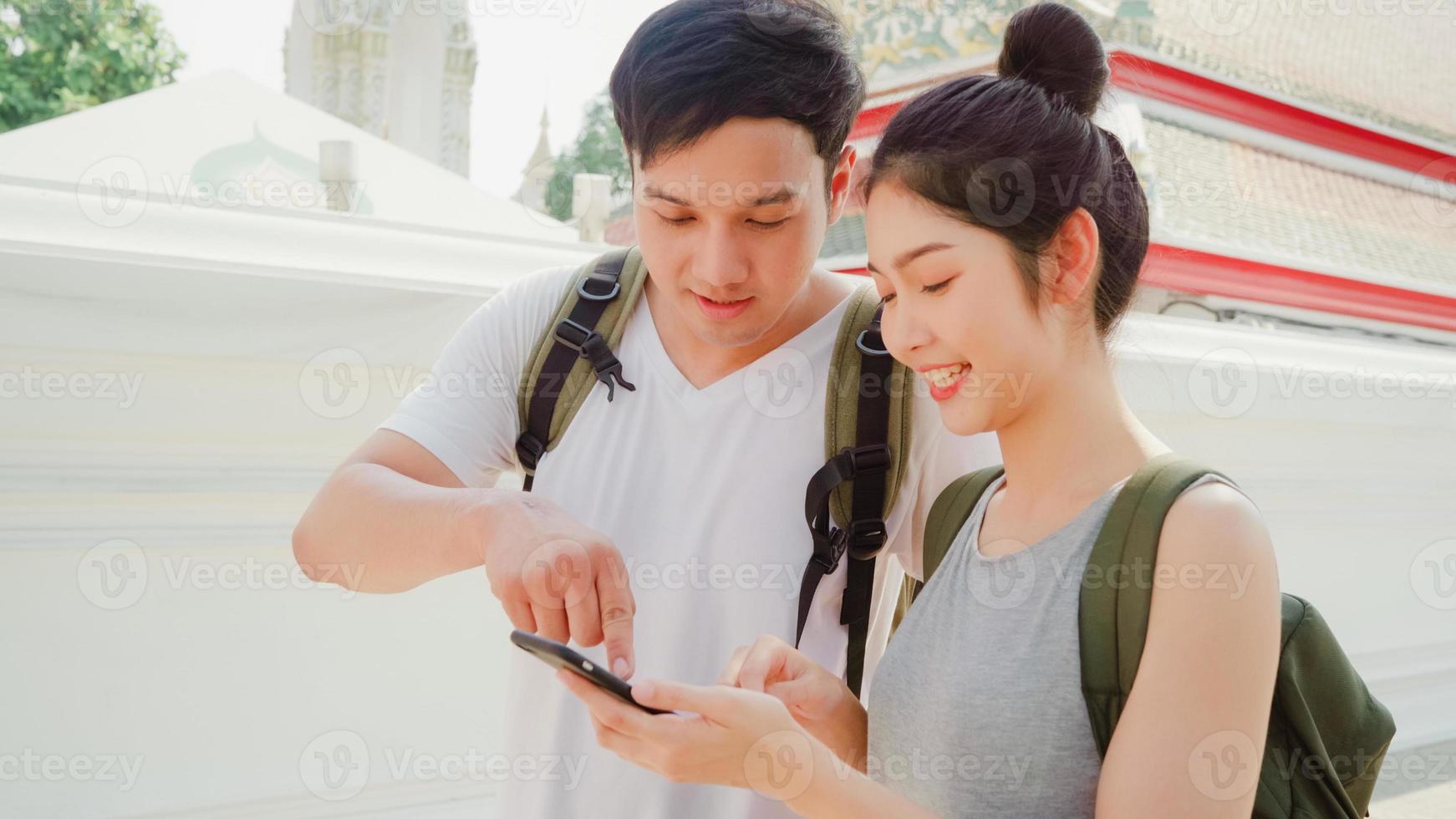 direzione delle coppie asiatiche del viaggiatore sulla mappa della posizione a bangkok, tailandia, coppia che utilizza il telefono cellulare guardando sulla mappa trova un punto di riferimento mentre trascorre un viaggio di vacanza. le coppie di stile di vita viaggiano nel concetto di città. foto