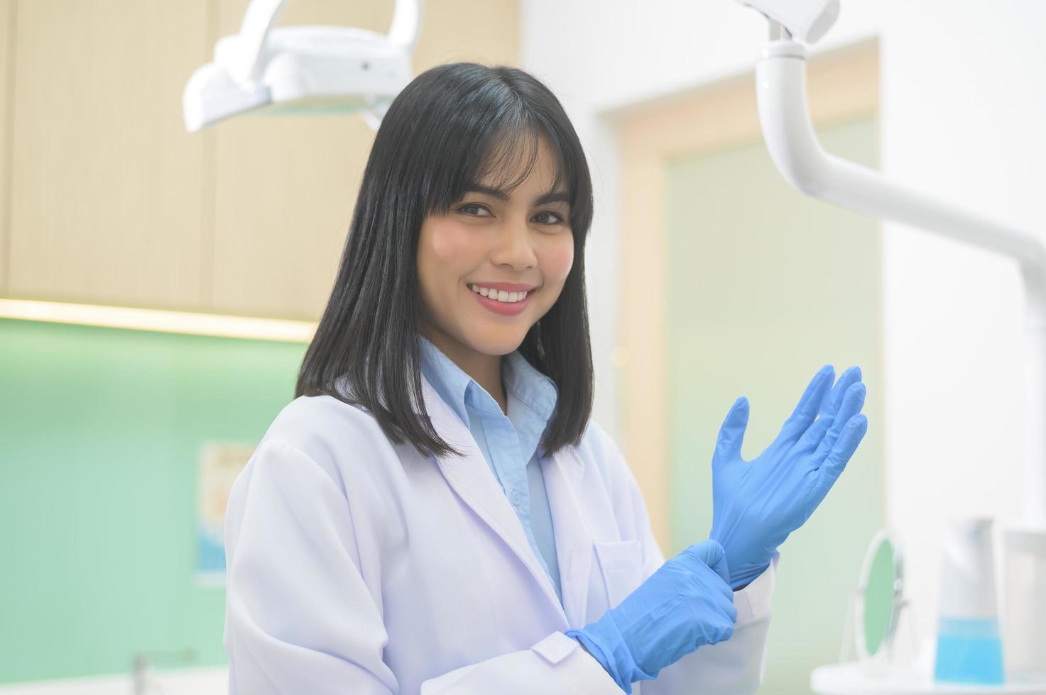 il dentista femminile che indossa guanti medici si prepara a lavorare in una clinica dentale, concetti dentali e assistenza sanitaria. foto