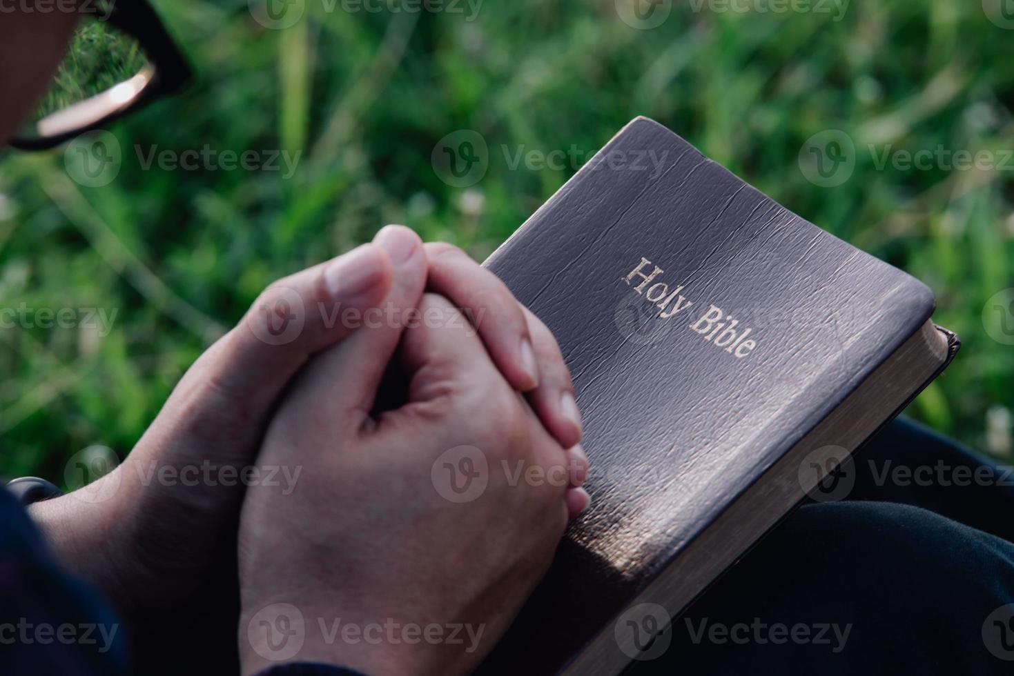 l'uomo asiatico sta leggendo la Scrittura o la Sacra Bibbia. fede e fede in Dio. concetto di religione foto