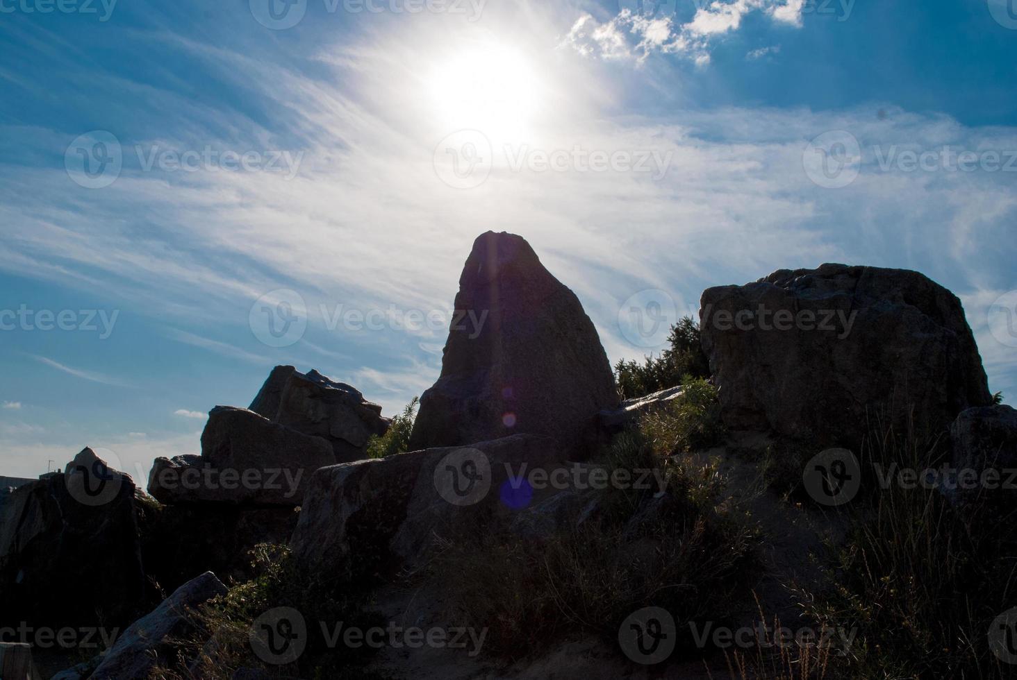 la pietra allinea il tramonto verticale, la pietra dritta, il sole della sera, lo sfondo della roccia da solo foto