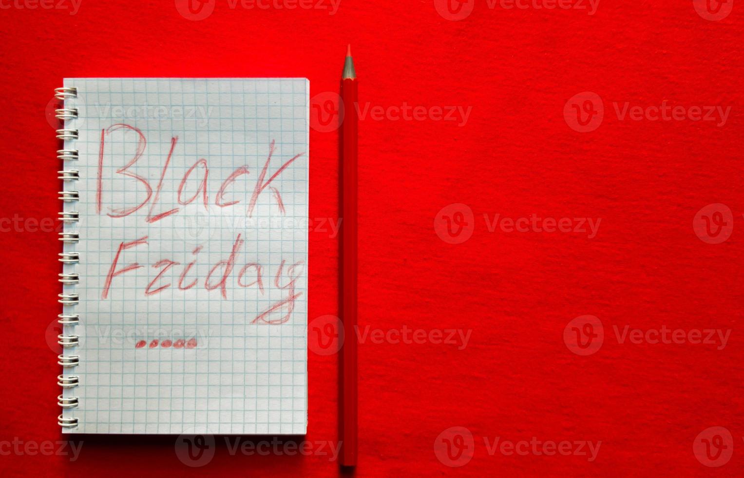 testo di vendita del venerdì nero scritto su un blocco note con una matita rossa su sfondo rosso. sfondo, concetto di vacanza. black friday - giornata internazionale di shopping, promozioni, sconti, saldi. foto