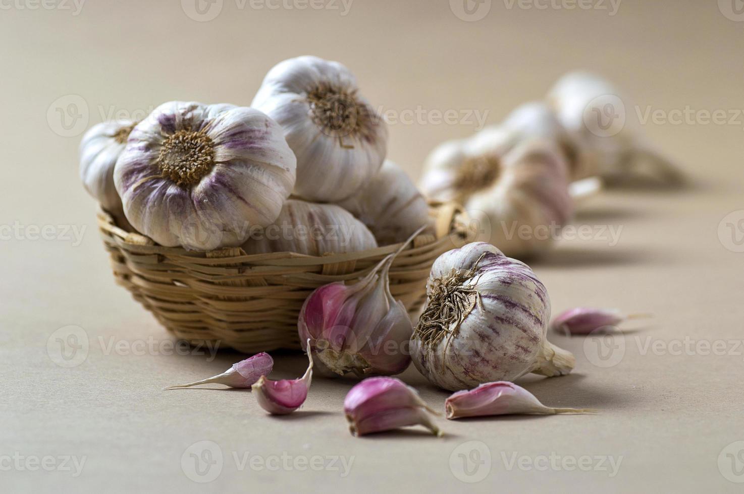 spicchi d'aglio e bulbo d'aglio nel cestino foto