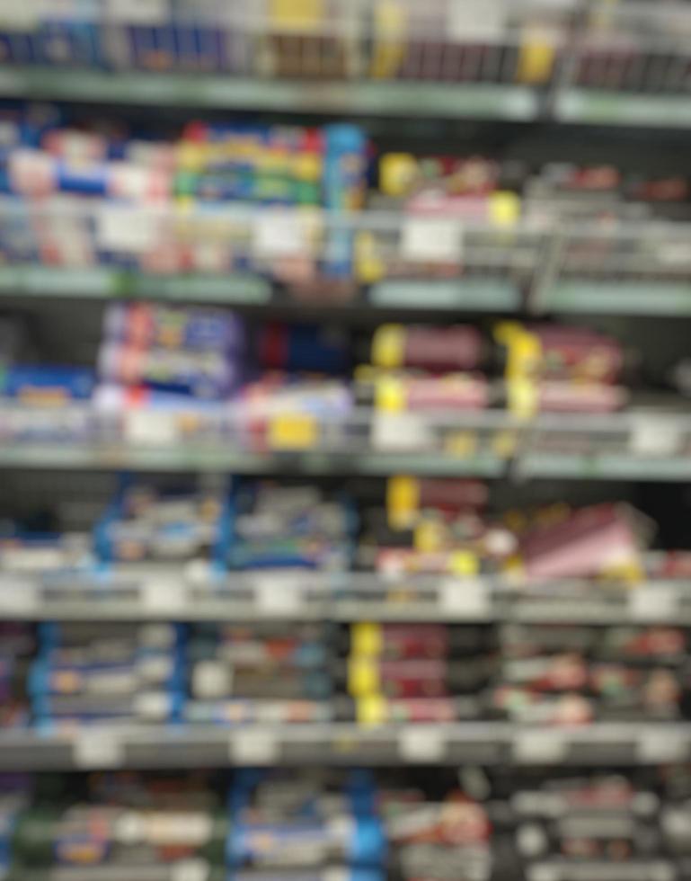 passaggio sfocato di un supermercato con scaffali con merci. passaggio astratto al supermercato con merci colorate sugli scaffali, può essere utilizzato come sfondo o per un altro tuo progetto foto