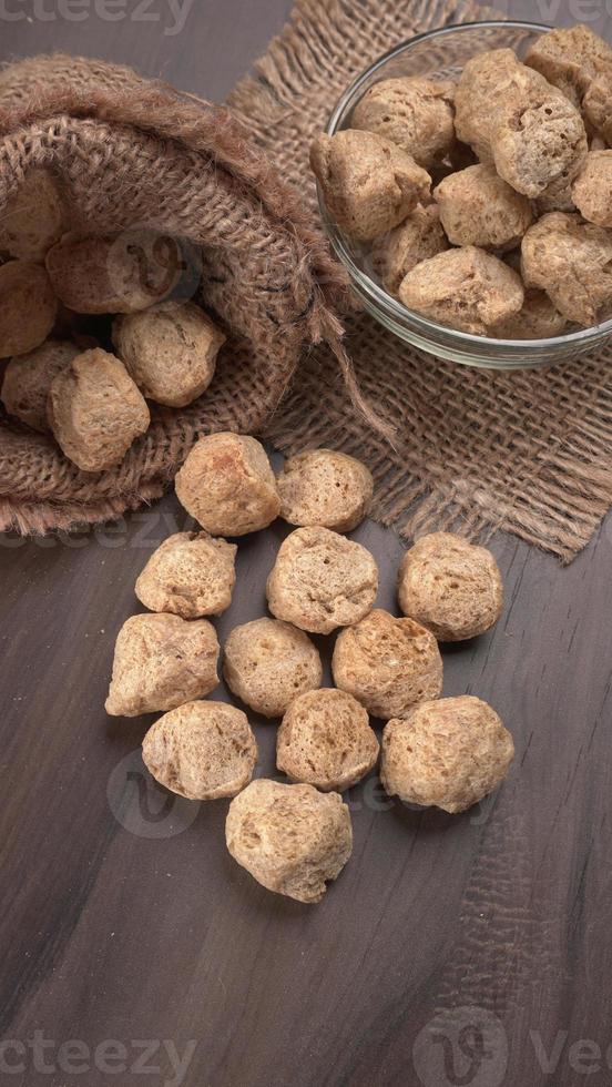 pezzi di soia cruda su sfondo scuro. carne di soia sana e nutriente, pezzi isolati concetto di cibo vegano. foto