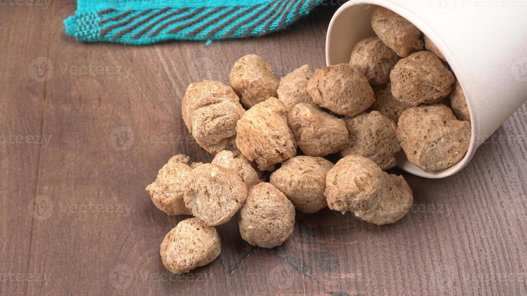 pezzi di soia cruda su sfondo scuro. carne di soia sana e nutriente, pezzi isolati concetto di cibo vegano. foto