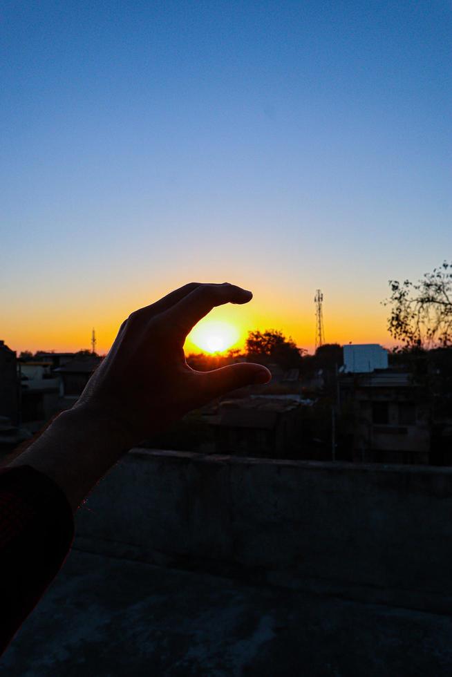 vista del tramonto o dell'alba dietro il segno della mano. foto