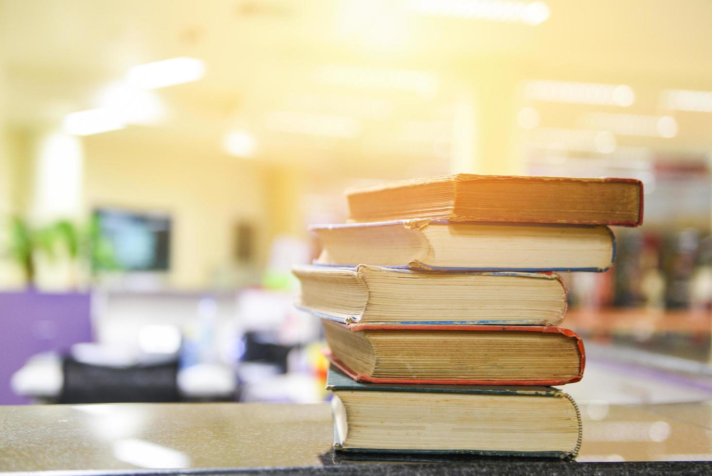 vecchi libri su un tavolo di legno - pila di libri aperta nella sala della biblioteca per il business e l'istruzione, torna al concetto di scuola foto