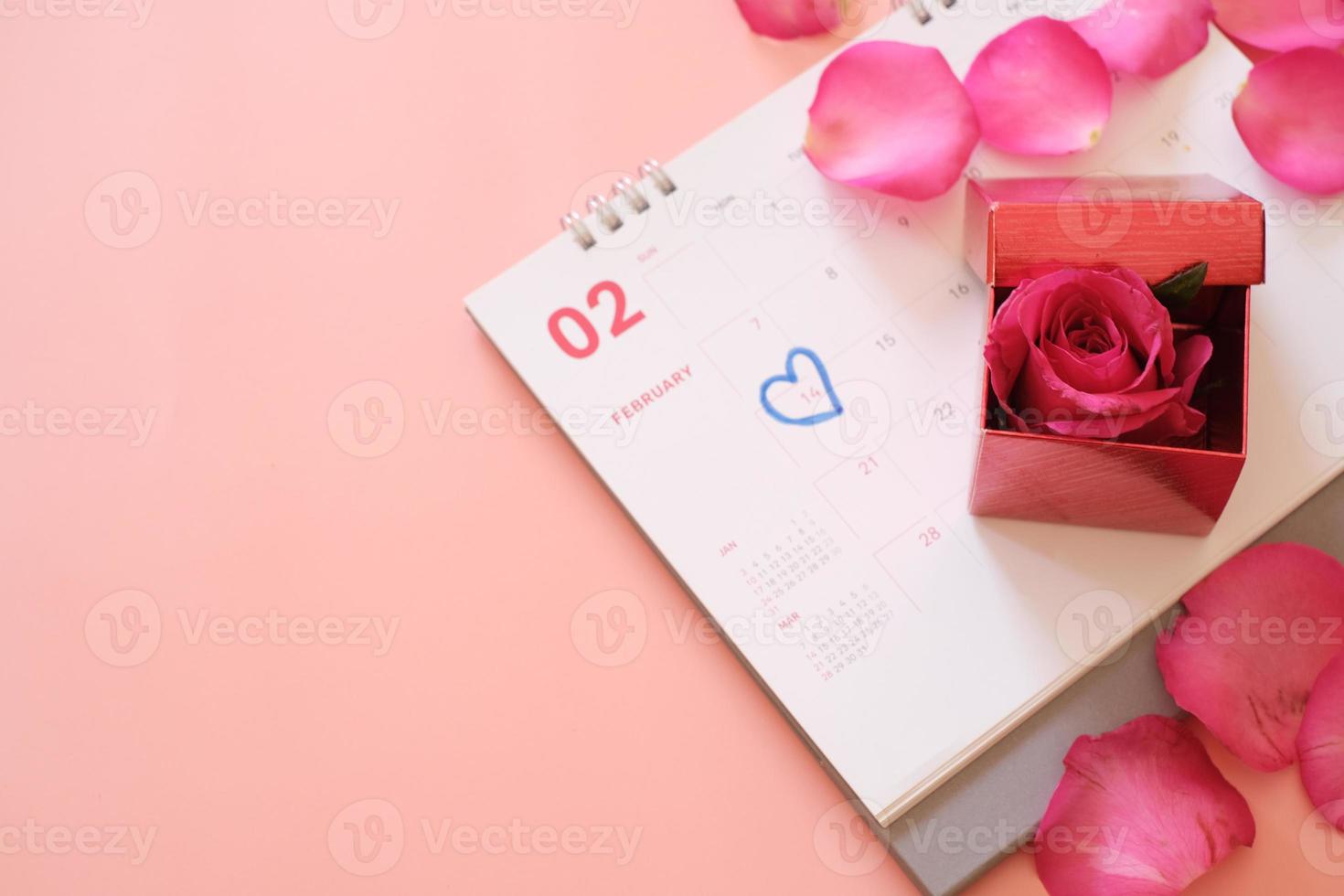 confezione regalo rosa rosa e rossa sul libro del calendario isolato su sfondo rosa con copyspace per il testo. concetto di san valentino. pianificazione pianificazione agenda, evento, organizzatore San Valentino. foto