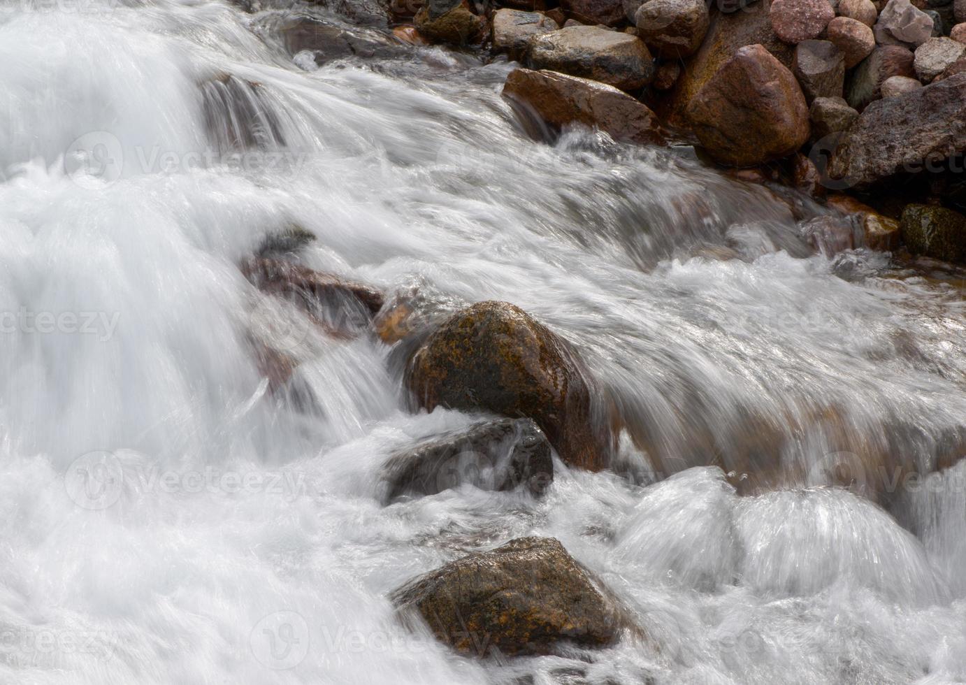 flusso di un fiume di montagna con pietre arrotondate foto