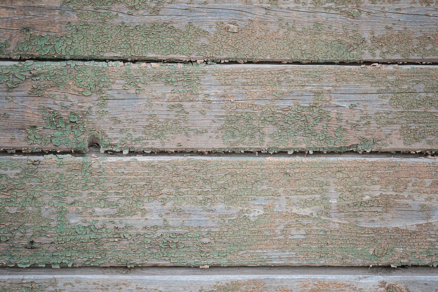 il muro è fatto di vecchie tavole con resti di vernice verde foto