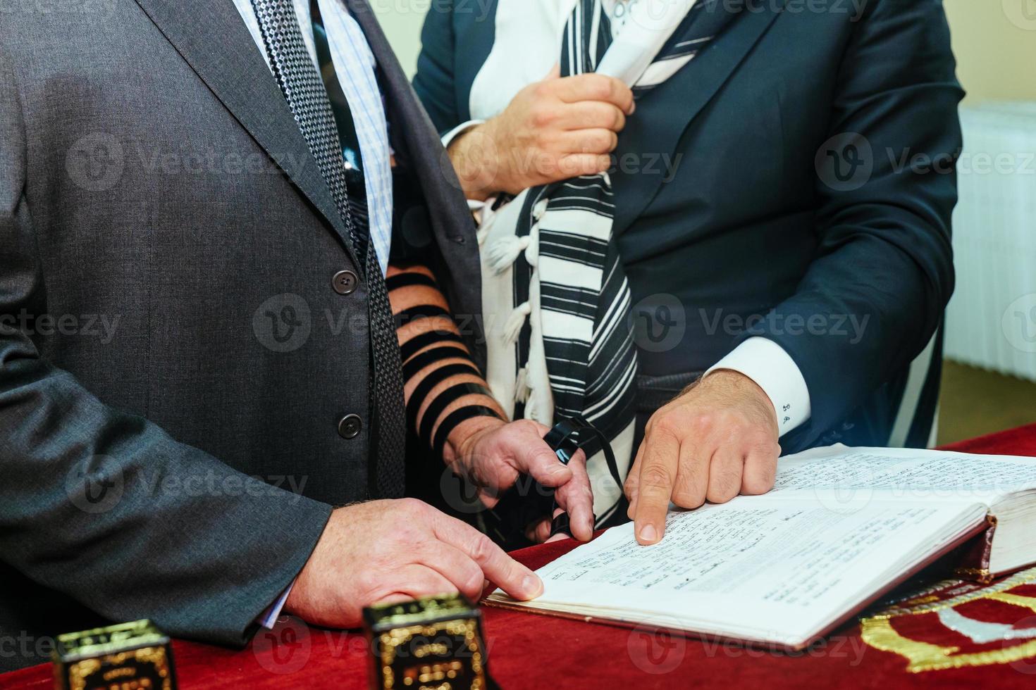 mano del ragazzo che legge la torah ebraica al bar mitzvah foto