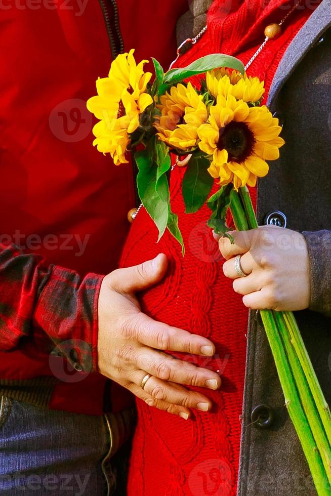 bella donna incinta in rosso in posa nel parco verde. giovane donna foto