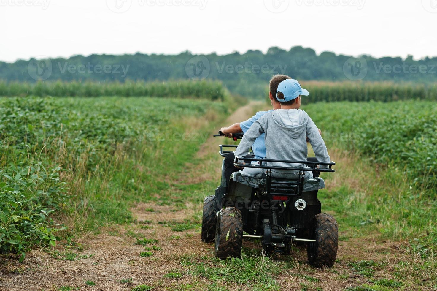 due fratelli che guidano un quad quad a quattro ruote. momenti felici dei bambini. foto