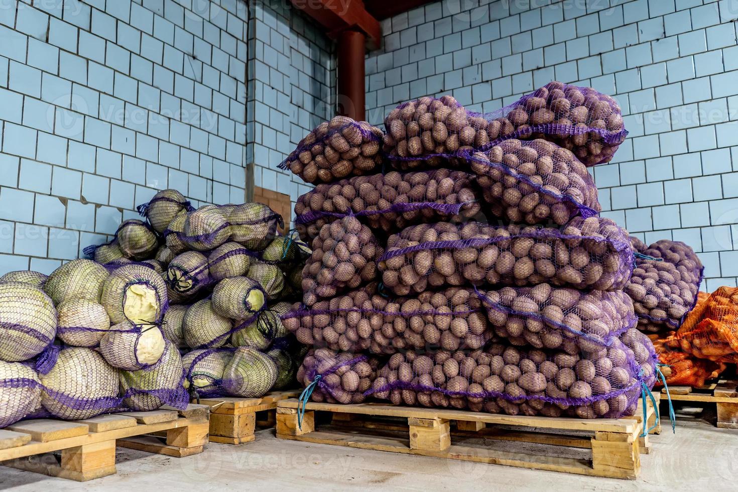 sacchetti a rete con verdure patate e cavoli nel magazzino del negozio foto