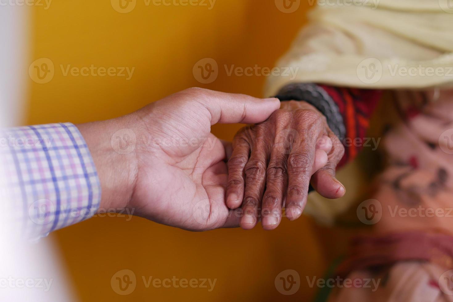 medico che tiene la mano di una donna anziana foto