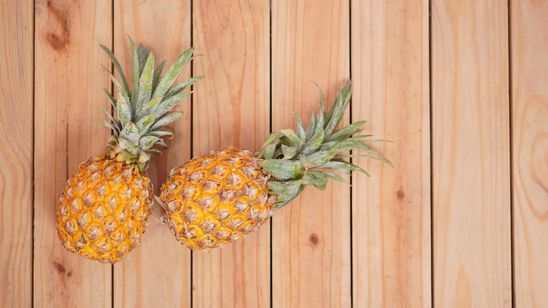 due ananas su uno sfondo di legno foto