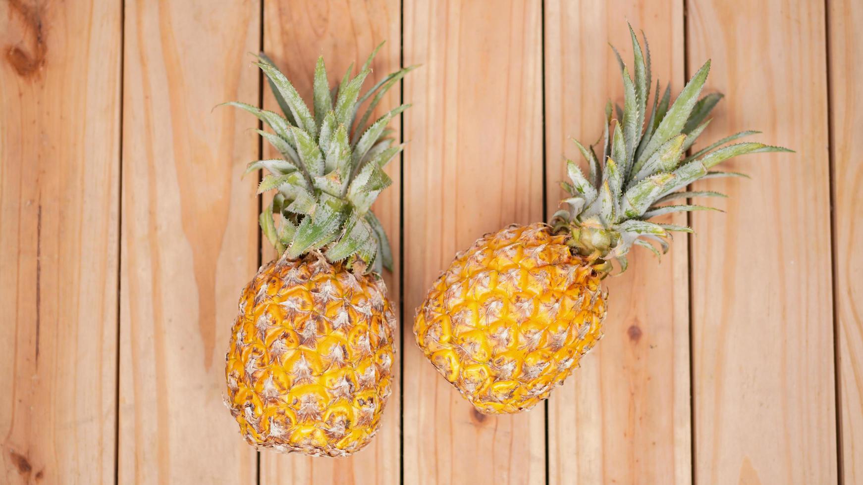 due ananas su uno sfondo di legno foto