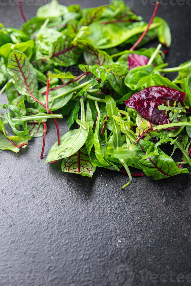 le foglie di insalata verde mescolano uno spuntino succoso microgreen pronto da mangiare sul tavolo foto