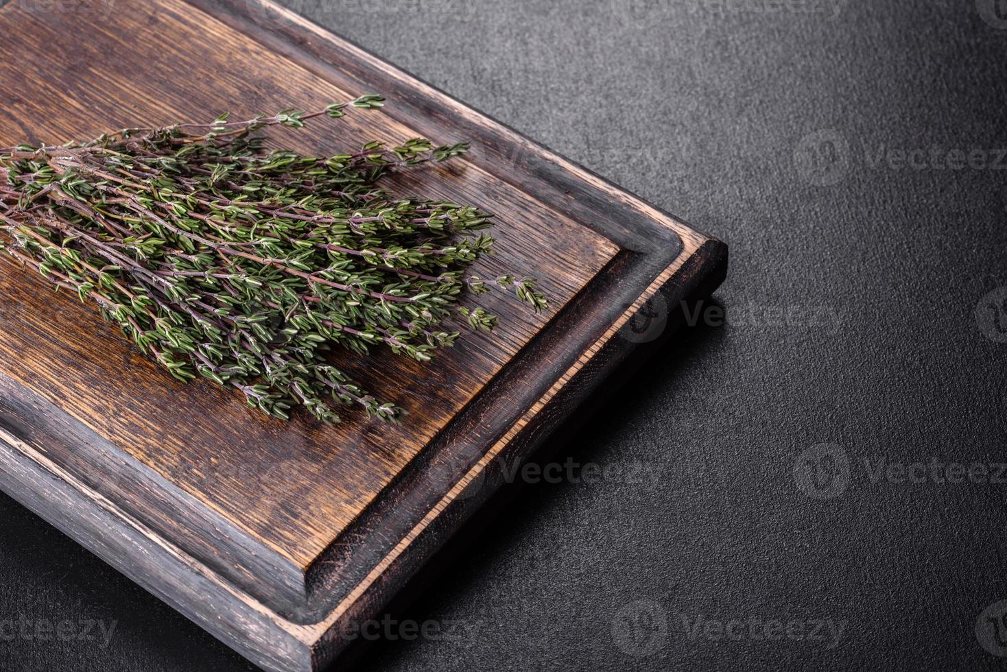 fascio di erba fresca di timo su un tagliere di legno foto
