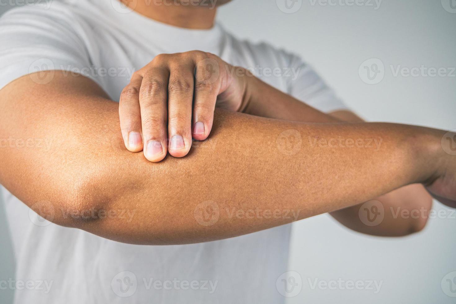 concetto di gomito del tennista. l'uomo usa le dita per massaggiarsi il braccio. conoscenza sanitaria. primo piano medio. foto