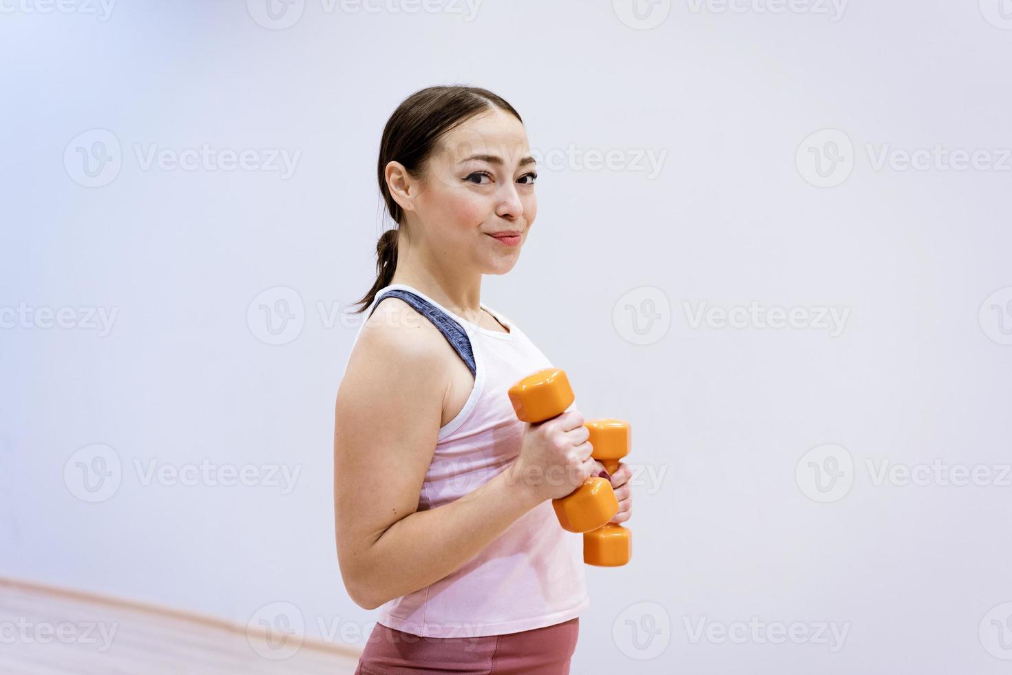 ritratto di una donna sportiva con manubri in mano foto