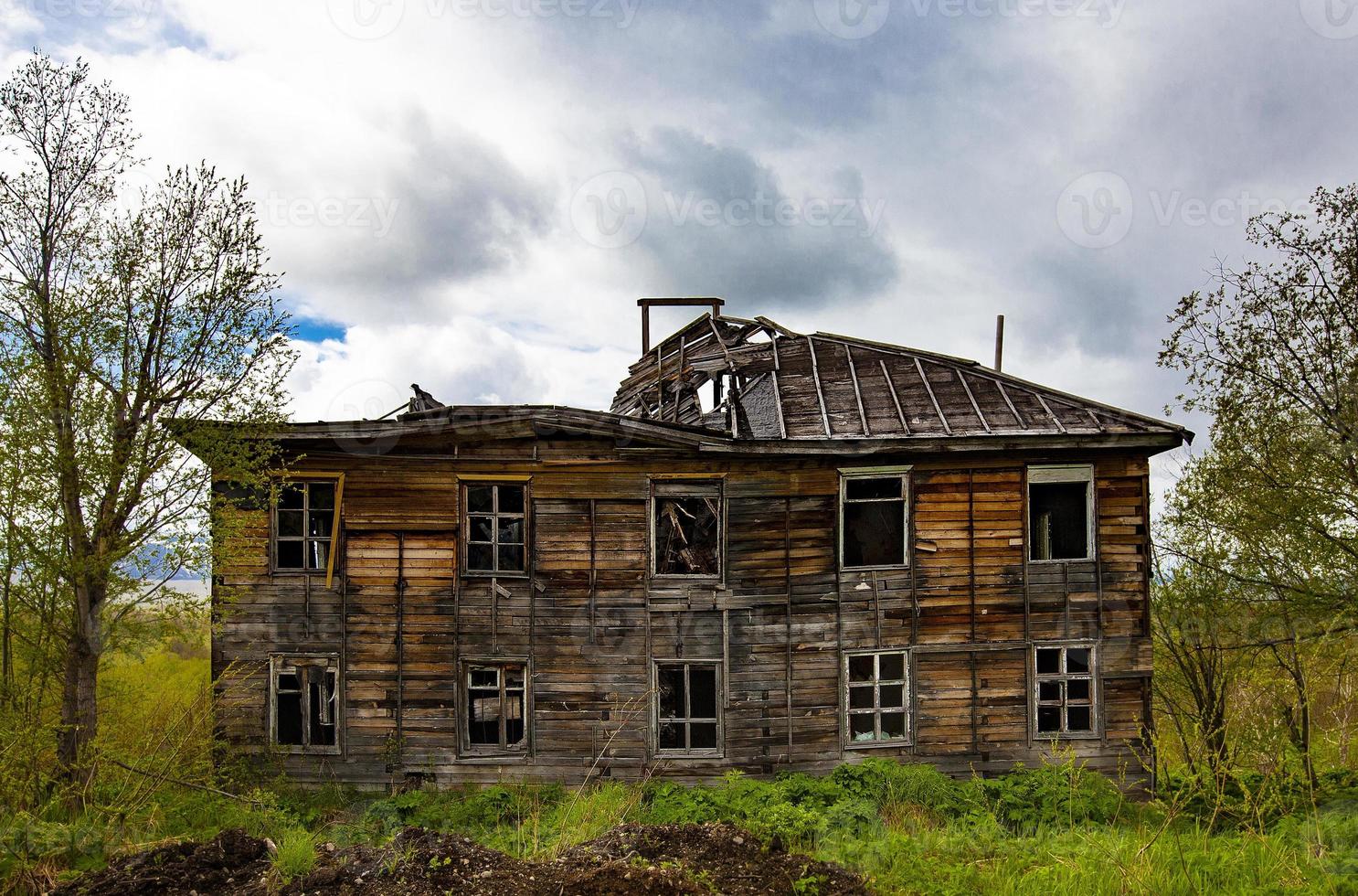 la vecchia casa di legno in rovina con le nuvole in primavera foto