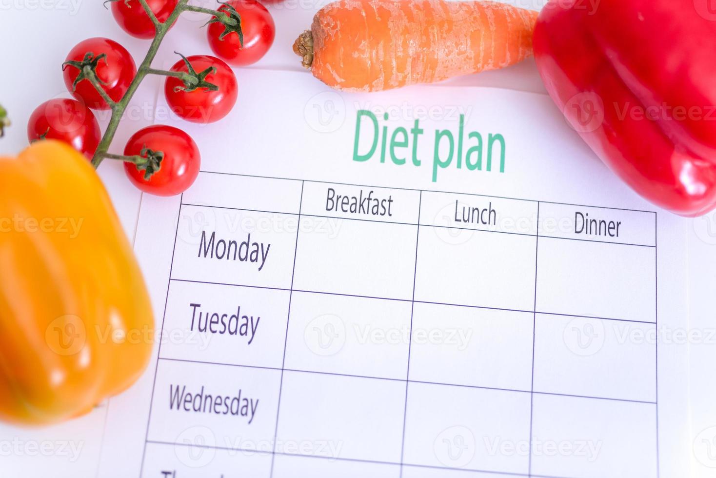 un programma di dieta su un pezzo di carta, accanto alle verdure. foto